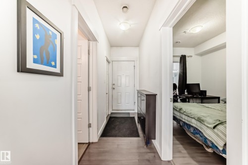 Entryway featuring wood-finish flooring, white paneled doors, and ceiling-mounted light fixtures - 316 10518 113 Street, Edmonton, AB - Indoor Photo Showing Other Room