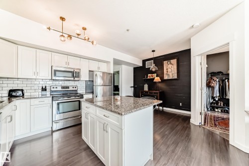 Kitchen featuring white cabinetry, stainless steel appliances, granite countertops, and subway tile backsplash - 316 10518 113 Street, Edmonton, AB - Indoor Photo Showing Kitchen With Stainless Steel Kitchen With Upgraded Kitchen