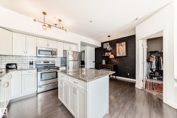 Kitchen featuring white cabinetry, stainless steel appliances, granite countertops, and subway tile backsplash - 