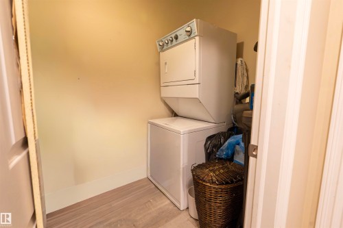 Dedicated laundry closet featuring a stacked washer and dryer - 203 4403 23 Street, Edmonton, AB - Indoor Photo Showing Laundry Room