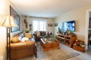 Living area featuring light wood-finish flooring, light neutral wall paint, and a sliding glass door - 203 4403 23 Street, Edmonton, AB  - Indoor Photo Showing Living Room 