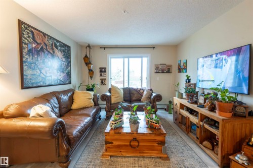 Living area featuring light-colored walls and wood-finish flooring - 203 4403 23 Street, Edmonton, AB - Indoor Photo Showing Living Room