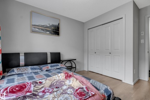 Room featuring light wood-finish flooring, light grey painted walls, and a textured white ceiling - 128 390 Windermere Road, Edmonton, AB - Indoor Photo Showing Bedroom
