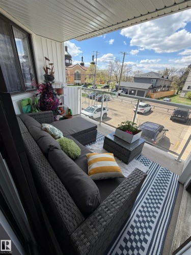 Balcony with glass railing, white vertical siding, and a textured ceiling - 205 10604 110 Avenue Nw, Edmonton, AB - Outdoor With Deck Patio Veranda