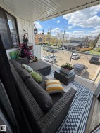 Balcony with glass railing, white vertical siding, and a textured ceiling - 
