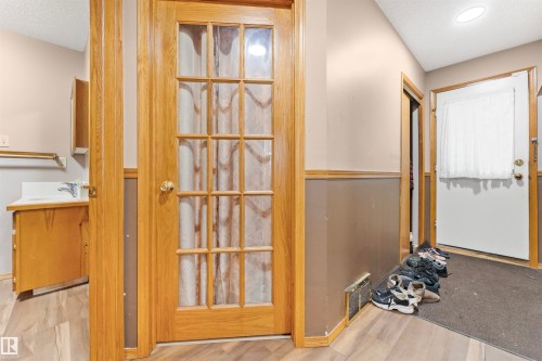 Entryway featuring wood-finish flooring, a wood-framed French door, an additional exterior door, and a utility sink with cabinetry - 4231 32 Avenue, Edmonton, AB - Indoor Photo Showing Other Room