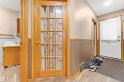 Entryway featuring wood-finish flooring, a wood-framed French door, an additional exterior door, and a utility sink with cabinetry - 