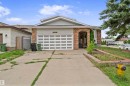Front exterior featuring brick facade accents, a two-car garage with a panel door, and a concrete driveway - 4231 32 Avenue, Edmonton, AB  - Outdoor 