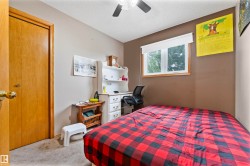 Room featuring a wood-trimmed window, neutral wall paint, and a built-in ceiling fan with light fixture - 