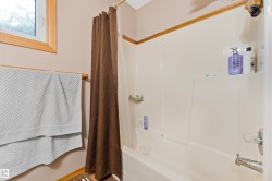 Integrated tub and shower unit with a white acrylic surround - 