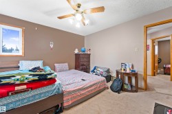 Carpeted room featuring a ceiling fan with light fixture, a window with wood trim, and two-tone wall finishes - 