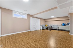 Spacious room with wood-finish flooring, neutral-toned walls, and recessed lighting - 