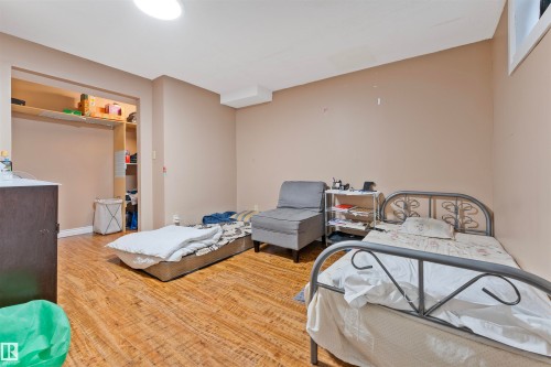 Spacious room featuring wood-finish flooring, recessed open shelving, and a cased opening - 4231 32 Avenue, Edmonton, AB - Indoor Photo Showing Other Room