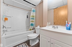 White bathtub and shower unit with an adjacent toilet - 
