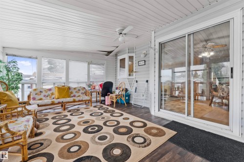 Sunroom featuring wood-finish flooring, white paneled ceiling, multiple windows, and a sliding glass door - 4231 32 Avenue, Edmonton, AB - Indoor Photo Showing Other Room