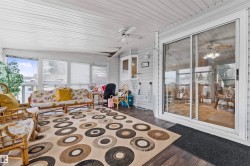 Sunroom featuring wood-finish flooring, white paneled ceiling, multiple windows, and a sliding glass door - 