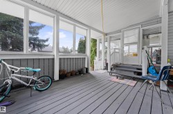 Enclosed porch featuring wood-finish flooring, multiple windows, and a beadboard ceiling - 