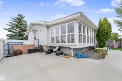 Light gray siding exterior featuring a multi-pane sunroom addition and a bay window - 