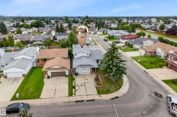 Two-story residential property featuring a light grey exterior siding and a matching grey shingle roof - 