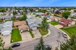 Residential neighborhood featuring a curvilinear street layout, mature landscaping, and diverse home styles - 