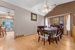 Dining area featuring wood-finish flooring, a vaulted ceiling, and a ceiling fan with integrated lighting - 