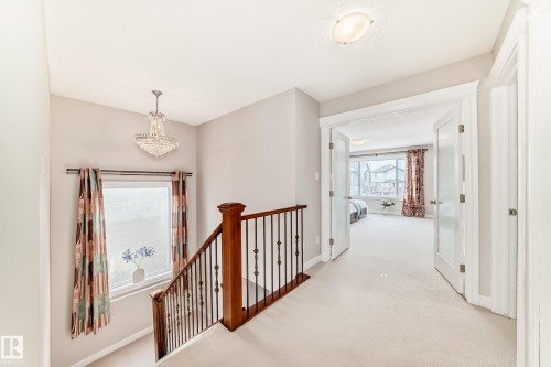 Upper landing with carpeted flooring, a decorative chandelier, and a large window - 1330 114B Street, Edmonton, AB - Indoor Photo Showing Other Room