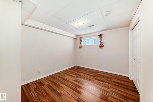Room featuring wood-finish flooring, a drop ceiling with recessed lighting, and a window with horizontal blinds - 1330 114B Street, Edmonton, AB - Indoor Photo Showing Other Room