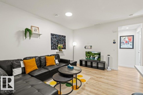 Living area featuring light wood-finish flooring, white walls, and recessed lighting - 21003 131 Avenue, Edmonton, AB 