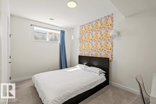 Carpeted room featuring a white ceiling and walls, a window with horizontal blinds, and a decorative wall covering - 21003 131 Avenue, Edmonton, AB 