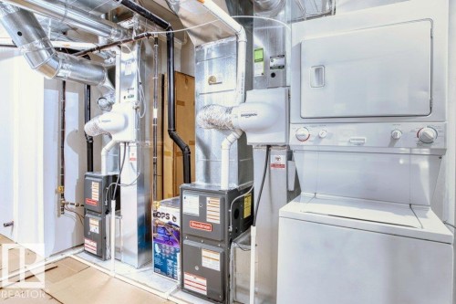 Dedicated utility area featuring a stacked washer and dryer, multiple HVAC units, and exposed ductwork - 21003 131 Avenue, Edmonton, AB 