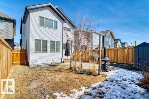 Rear exterior of the property featuring white siding and multiple windows - 21003 131 Avenue, Edmonton, AB 