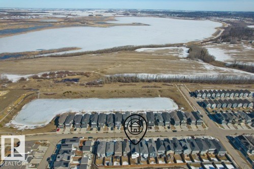 Residential community featuring a frozen pond and direct access to a larger frozen body of water - 21003 131 Avenue, Edmonton, AB 