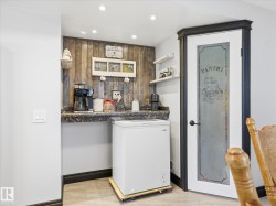 Dedicated beverage station featuring a wood-panel accent wall, recessed lighting, and a granite-finish countertop - 