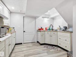 Kitchenette featuring light wood-finish flooring and white cabinetry - 