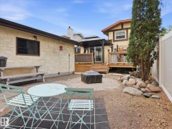Backyard space featuring a paver patio with a built-in fire pit, a multi-level wooden deck with a covered gazebo, and established perimeter trees - 
