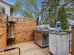 Outdoor wood deck featuring a horizontal wood privacy screen and perimeter railing - 