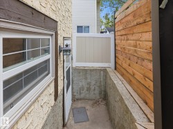 Exterior stucco finish with a contrasting dark brown trim, white-framed window, and outdoor wall lantern - 