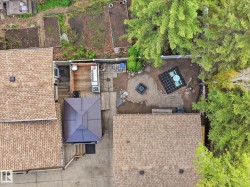 Expansive outdoor living area featuring a stone paver patio, integrated fire pit, and wood deck - 