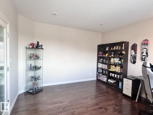 Spacious room featuring rich wood-finish flooring, recessed ceiling lighting, and light-toned wall finishes - 820 Drysdale Run, Edmonton, AB - Indoor Photo Showing Other Room