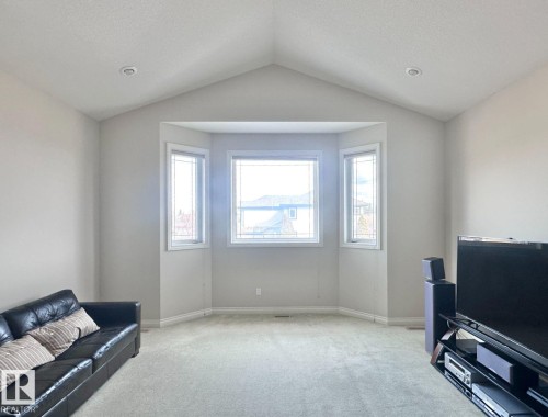 Spacious room featuring a vaulted ceiling and a bay window - 820 Drysdale Run, Edmonton, AB - Indoor Photo Showing Other Room