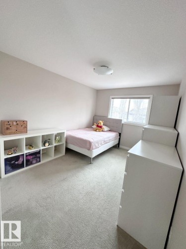 Carpeted room with neutral wall tones and a window providing natural light - 820 Drysdale Run, Edmonton, AB - Indoor Photo Showing Bedroom