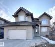 Stucco exterior featuring a dual garage, multi-pane windows, a gabled roofline, and a prominent arched entryway - 820 Drysdale Run, Edmonton, AB  - Outdoor With Facade 