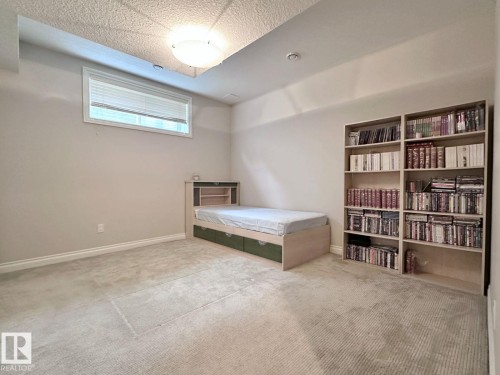 Carpeted room featuring a ceiling-mounted light fixture and a single window with blinds - 820 Drysdale Run, Edmonton, AB - Indoor