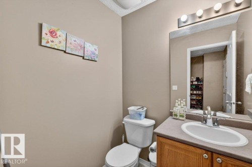 The property features a bathroom with a vanity, an integrated sink, a mirror, and a toilet - 16107 92 Street, Edmonton, AB - Indoor Photo Showing Bathroom