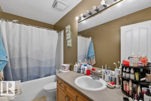 Bathroom featuring a vanity with a countertop sink, a full-width mirror, and overhead lighting - 16107 92 Street, Edmonton, AB - Indoor Photo Showing Bathroom