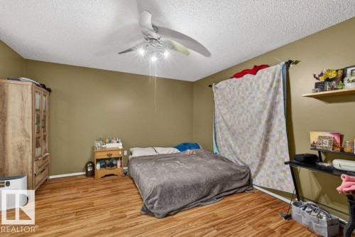 This room features wood-look flooring and a ceiling fan with integrated lighting - 16107 92 Street, Edmonton, AB - Indoor Photo Showing Bedroom