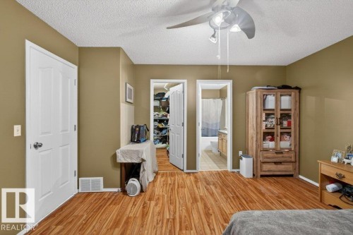 The property features durable plank flooring, a ceiling fan with integrated lighting, and a white six-panel door - 16107 92 Street, Edmonton, AB - Indoor