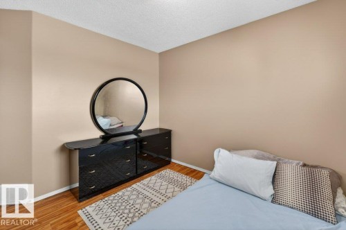 This interior space features hardwood floors, light beige walls, and a white textured ceiling - 16107 92 Street, Edmonton, AB - Indoor