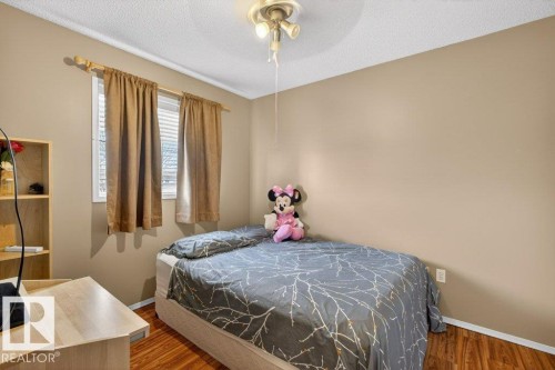 This room features hardwood flooring, a window with blinds and drapes, and a ceiling fan with light fixture - 16107 92 Street, Edmonton, AB - Indoor Photo Showing Bedroom