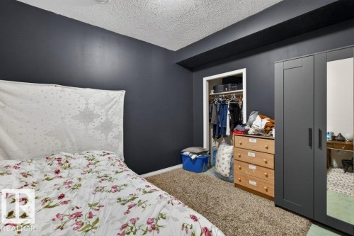 The property features a room with dark walls and a textured ceiling - 16107 92 Street, Edmonton, AB - Indoor Photo Showing Bedroom